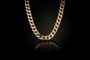 Gyllene Bismarckhalsband mot svart bakgrund med spegling