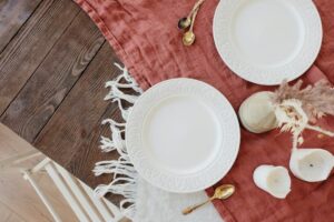 Rustikt dukat bord med vita tallrikar, linnetextil och torkade växter